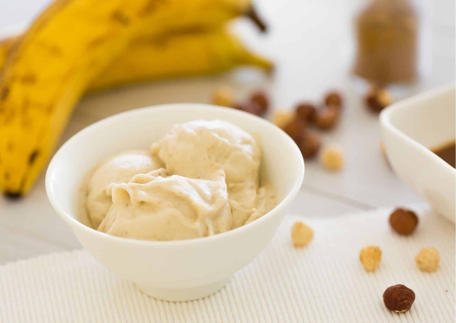 Nicecream in einer Porzellanschüssel mit Bananen im Hintergrund